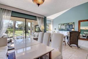 a living room with a table and white chairs at Golf Front - Sawgrass Gate Community in Ponte Vedra Beach