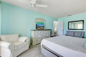 a bedroom with a bed and a chair and a mirror at Golf Front - Sawgrass Gate Community in Ponte Vedra Beach