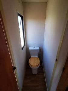 a small bathroom with a toilet with a wooden seat at Minicasa con vistas al mar in Casabermeja +7 photos