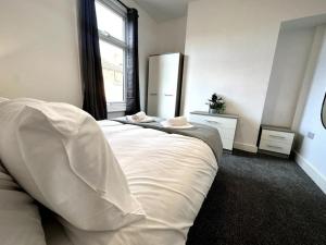 um quarto com uma grande cama branca e uma janela em Middleton House by Blue Skies Stays em Hartlepool