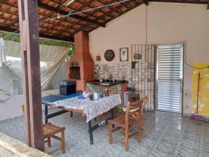 a kitchen with a table and chairs in a room at Casa com piscina perto da praia in São Sebastião
