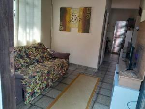 a living room with a couch and a painting on the wall at Casa com piscina perto da praia in São Sebastião