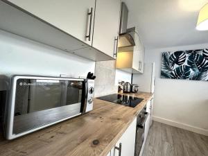 uma cozinha com um micro-ondas e um balcão de madeira em Middleton House by Blue Skies Stays em Hartlepool