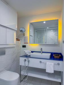 a white bathroom with a sink and a toilet at Batumi VIP hotel in Batumi