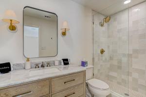 a bathroom with a toilet and a sink and a mirror at SOBE Retreat - Designers Dream - Fenced backyard in Jacksonville Beach +61 photos