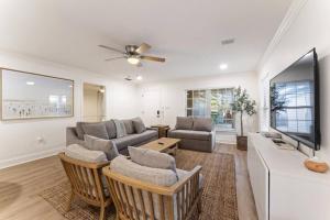 a living room with a couch and a tv at SOBE Retreat - Designers Dream - Fenced backyard in Jacksonville Beach