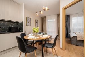 a kitchen and dining room with a table and chairs at AYCON APARTMENTS - MODERN SPACE in Warsaw