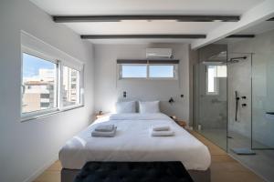 sypialnia z dużym białym łóżkiem i szklanym prysznicem w obiekcie One Shade of Grey Loft with Private Terrace w Atenach