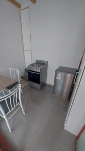 a kitchen with a stove and a table and a chair at El Capricho Paracas in Paracas