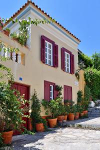 una casa con puertas rojas y macetas delante en At the foot of Acropolis. en Athens