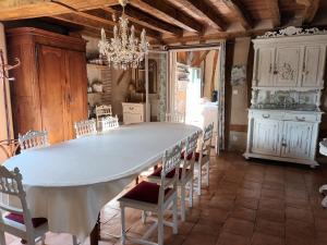 ein Esszimmer mit einem großen weißen Tisch und Stühlen in der Unterkunft Au bout du monde 1 in Les Hermites