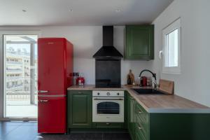 eine Küche mit grünen Schränken und einem roten Kühlschrank in der Unterkunft One Shade of Grey Loft with Private Terrace in Athen
