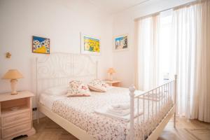 Un dormitorio con una cama blanca y una ventana. en Dimora Bruno e Rubina (centrale a Capri), en Capri
