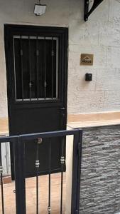 une porte noire sur le côté d'un bâtiment dans l'établissement the cousins' house, à Palerme