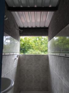 a bathroom with a shower with a sink and a window at Casa de Campo El Regalo in Norcasia
