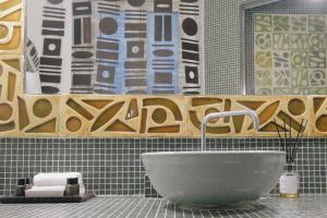 baño con lavabo blanco y pared de azulejos en 3 Rooms 10 Corso Como Milano, en Milán