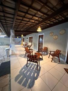 a patio with wooden chairs and tables in a building at CasaMar21- 12 km de Maceió e 10 km FRAN6 in Maceió