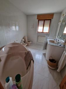 łazienka z wanną, umywalką i toaletą w obiekcie Los Kukos Casa Rural w mieście Riaño