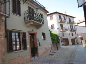 eine Gasse mit einem Gebäude mit einem Balkon in der Unterkunft Alla Torre - nel cuore del Borgo storico in Castagnole Lanze