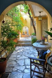 an outdoor patio with an archway and tables and plants at At the foot of Acropolis. in Athens