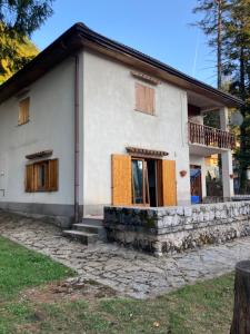 biały dom z drewnianymi drzwiami i oknami w obiekcie Villa Malgary w mieście Laceno