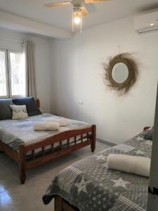 1 Schlafzimmer mit 2 Betten und einem Wandspiegel in der Unterkunft Villa ARMONIA in Benissa