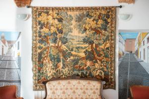 a large tapestry hanging on a wall with a couch at Alojamiento El Monasterio in Almonaster la Real