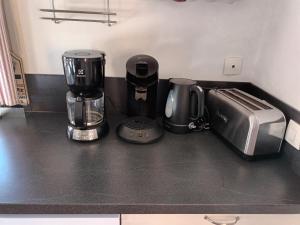 twee koffiezetapparaten en een broodrooster op een aanrecht bij Au bout du monde 1 in Les Hermites