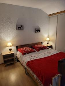 1 dormitorio con 1 cama con sábanas rojas y 2 lámparas en Le Chalet, Superbe Duplex 3 étoiles proche du centre des Rousses, 5 personnes, Draps inclus, en Les Rousses