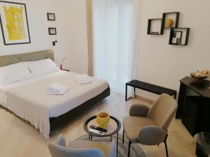 I Canti Comfort Rooms في باليرمو: غرفة نوم بسرير وكرسي وطاولة