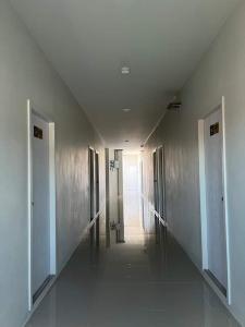 a hallway in a building with a hallway leading to a door at ศิริณเพลส in Ubon Ratchathani