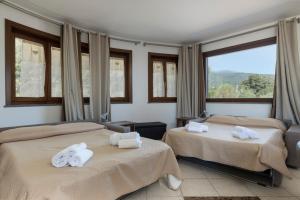 a hotel room with two beds with towels on them at Villa Vulcano, tra l'Etna e il mare in Zafferana Etnea