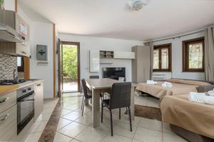 a kitchen and living room with a table and a room with two beds at Villa Vulcano, tra l'Etna e il mare in Zafferana Etnea
