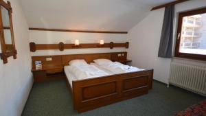 a bedroom with a bed with white pillows on it at Gästepension Hermann Arnold in Sölden