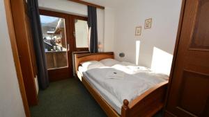 a bedroom with a large bed with a window at Gästepension Hermann Arnold in Sölden