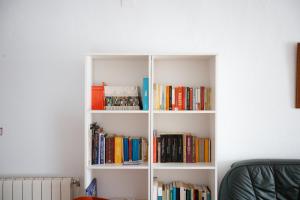 a white book shelf filled with books at Alojamiento El Monasterio in Almonaster la Real