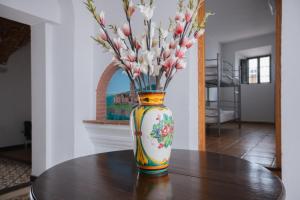 Eine Vase mit Blumen auf einem Tisch in der Unterkunft Alojamiento El Monasterio in Almonaster la Real