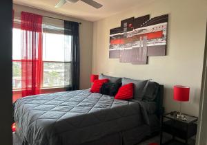 Schlafzimmer mit einem Bett mit roten Kissen und einem Fenster in der Unterkunft Best area of Houston, TX. (Midtown Area) in Houston