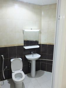 a bathroom with a toilet and a sink at B&B Hostel in Dubai