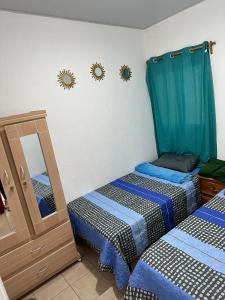 two twin beds in a room with a mirror at Casa Amueblada en Santa Ana in Santa Ana