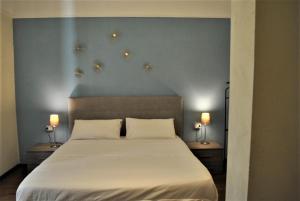 プラートにあるAppartamento Guidoのベッドルーム1室(枕2つ、ランプ2つ付)