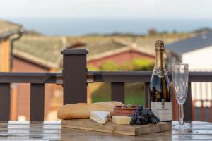 a bottle of wine and a glass on a table at 28 Ocean Terrace Lodge - Mullacott Park in Ilfracombe