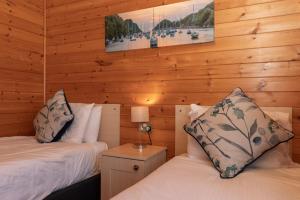 two beds in a room with wooden walls at 28 Ocean Terrace Lodge - Mullacott Park in Ilfracombe