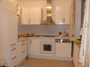 a kitchen with white cabinets and a sink at Eichenblick in Prerow