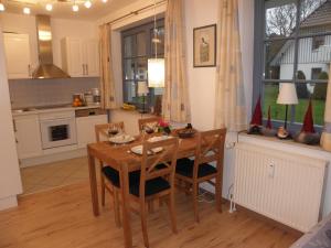 a kitchen and dining room with a wooden table and chairs at Eichenblick in Prerow