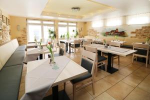 un restaurante con mesas, sillas y ventanas en Hotel Pension Kirschstein en Wolgast