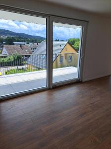 um quarto vazio com duas grandes janelas com vista em Marko's Wohnung em Rudersberg