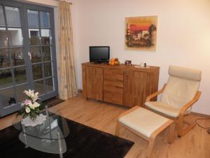 a living room with a chair and a television at Eichenblick in Prerow +20 photos