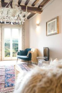 uma sala de estar com um sofá azul e um lustre em Luxury Townhouse View of Tuscany em Ficulle