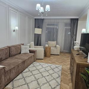 ein Wohnzimmer mit einem Sofa und 2 Stühlen in der Unterkunft Apartament M2 Vatra Dornei in Vatra Dornei